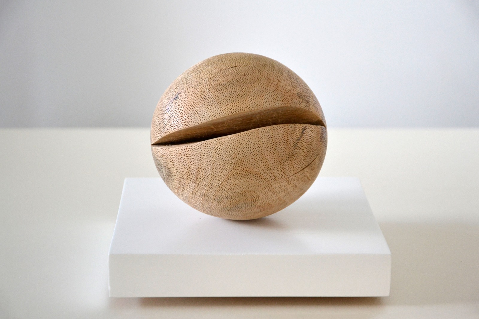 Wooden sphere sculpture on a pedestal